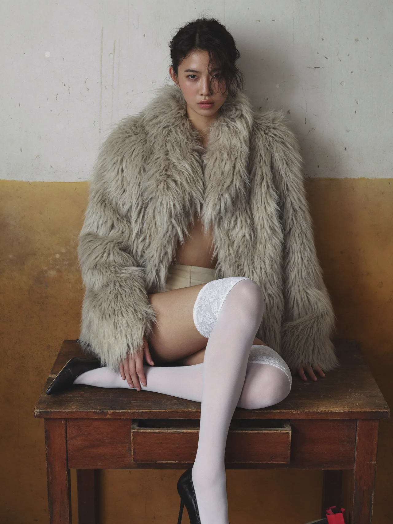 Textured fur, white stockings and a seated pose against an ochre wall